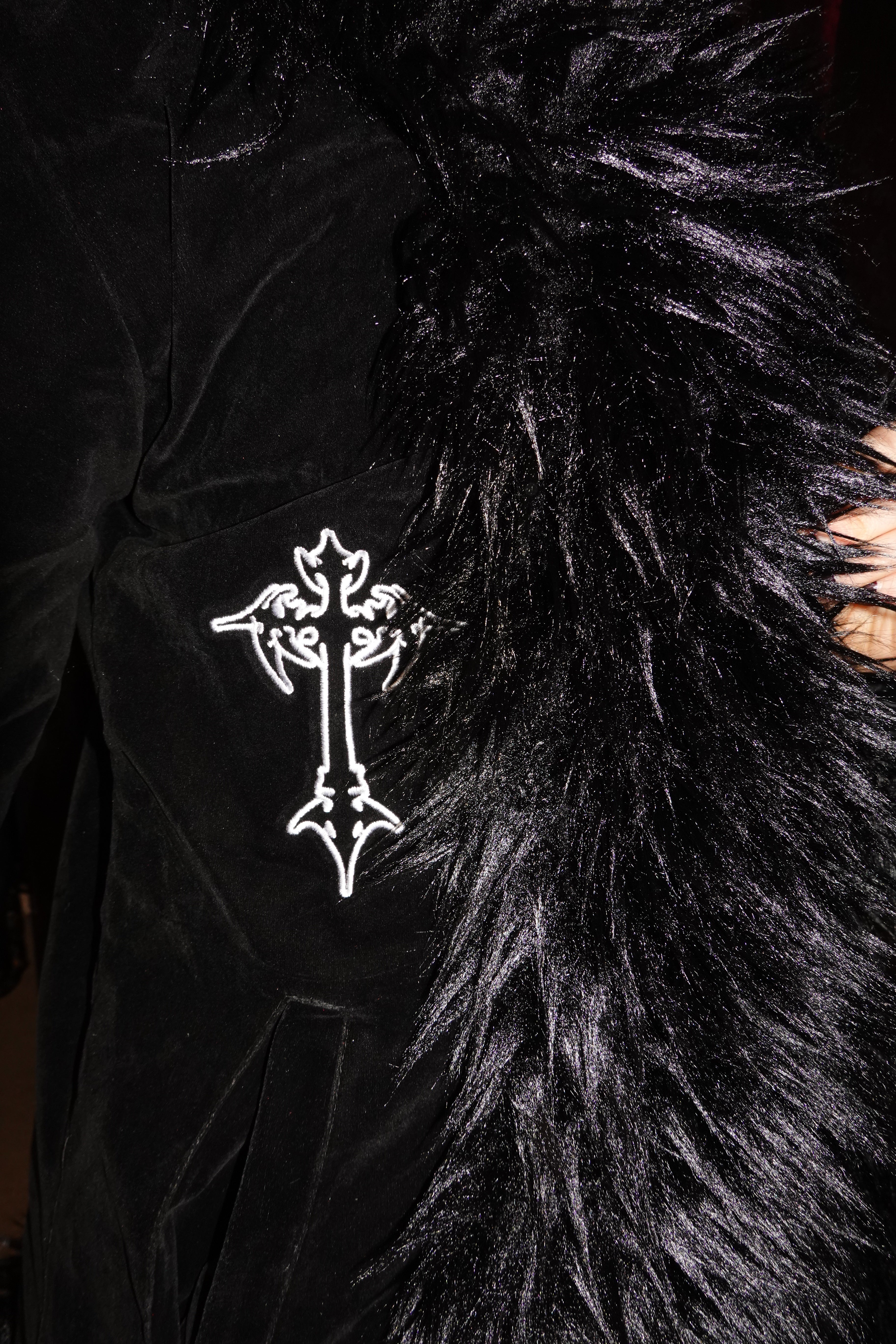 Close-up of black velvet faux fur coat showcasing embroidered white cross design. On model - Raven's Embrace - FM2U Clothing Australia | Gothic Alternative Whimsical Ethical Fashion