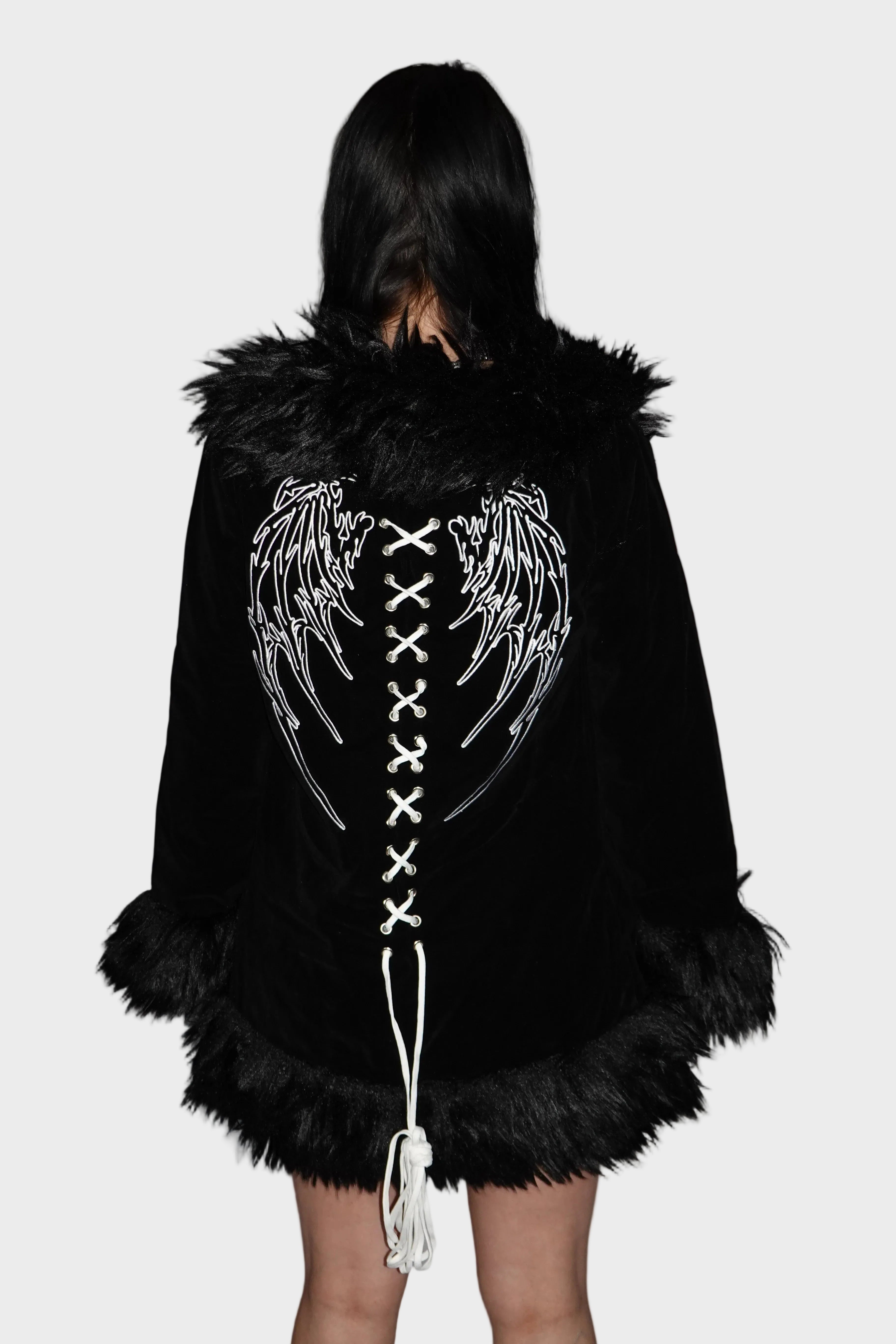 Back view of black velvet coat with fur trim showcasing bold embroidered white angel wings and cross-stitch design. On model - Raven's Embrace - FM2U Clothing Australia | Gothic Alternative Whimsical Ethical Fashion