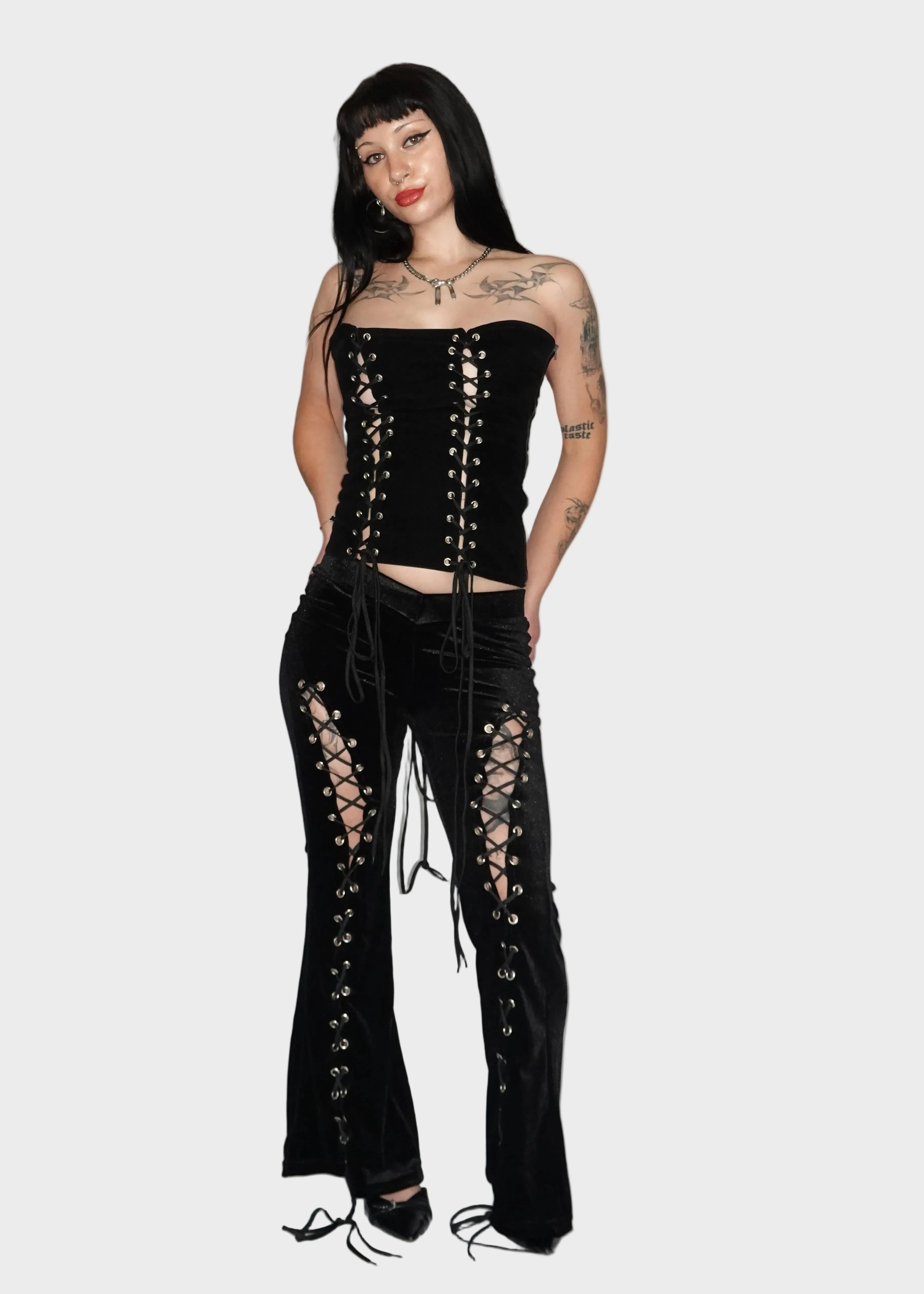 Alt baddie model wearing black velvet alternative flared pants with lace-up cutout leg detail and fitted low-rise V waistband - Ravencross Pants - FM2U Clothing Australia | Gothic Alternative Whimsical Ethical Fashion