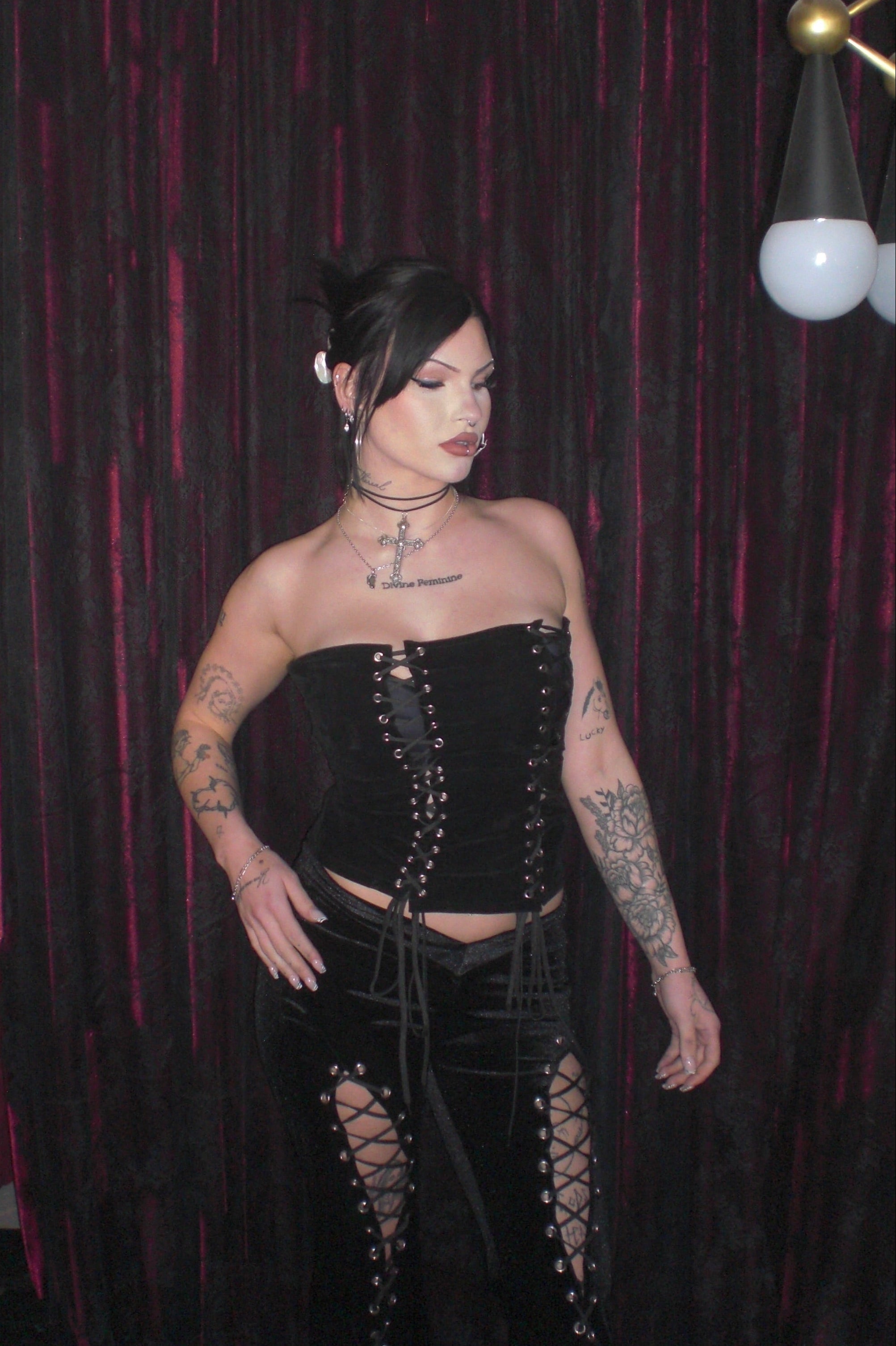 Close-up of baddie model posing in eyelet black velvet alternative top with adjustable lace-up back and side zip closure paired with Ravencross Pants - Ravencross Top - FM2U Clothing Australia | Gothic Alternative Whimsical Ethical Fashion
