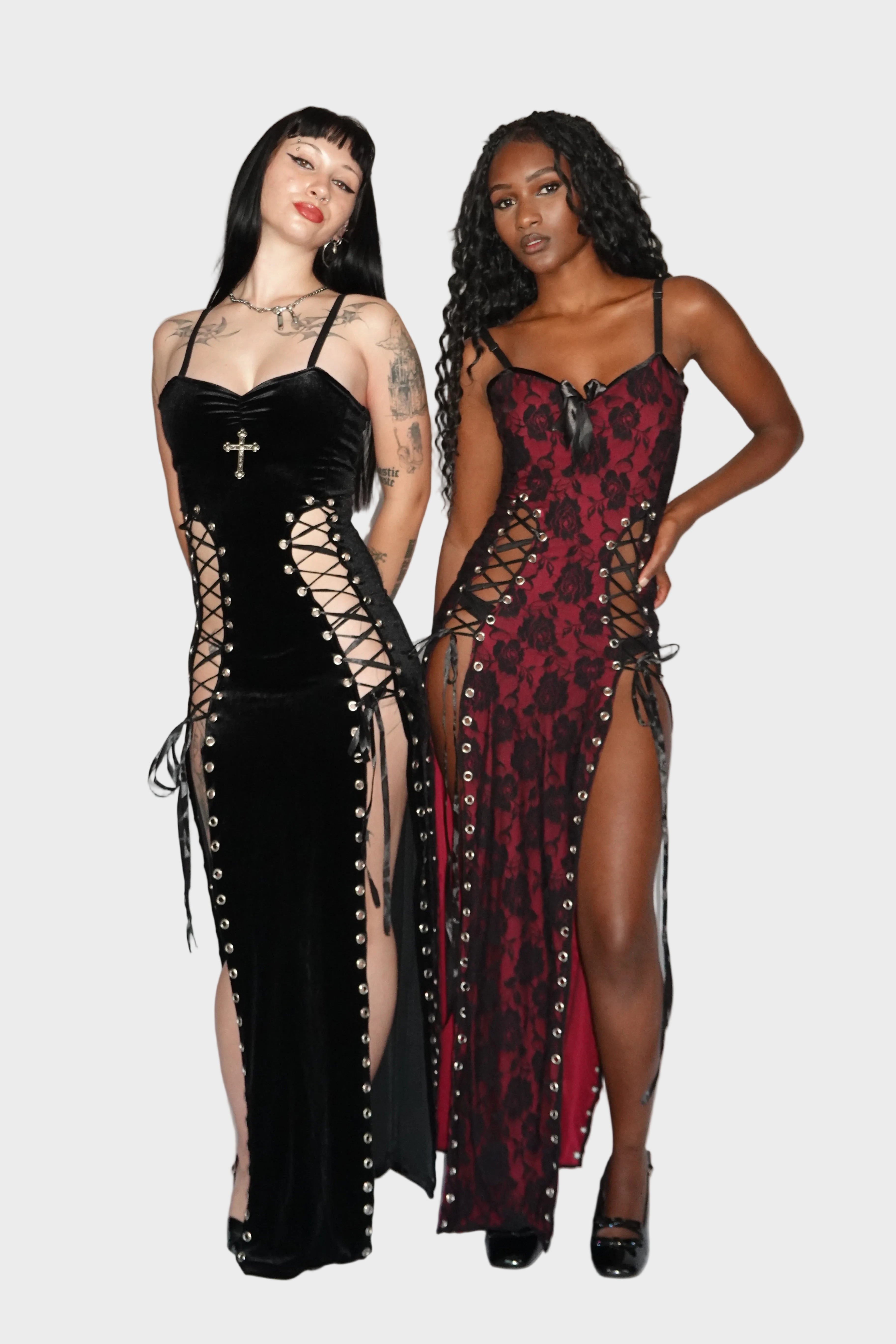 Group full-body shot of black, velvet dress with cross bust embellishment on left, followed by a red spandex dress overlayed with black floral lace and a black ribbon on the neckline on right. On left model - Ravencross dress (Black), on right model - Ravencross dress (Vampiress) FM2U Clothing Australia | Gothic Alternative Whimsical Ethical Fashion