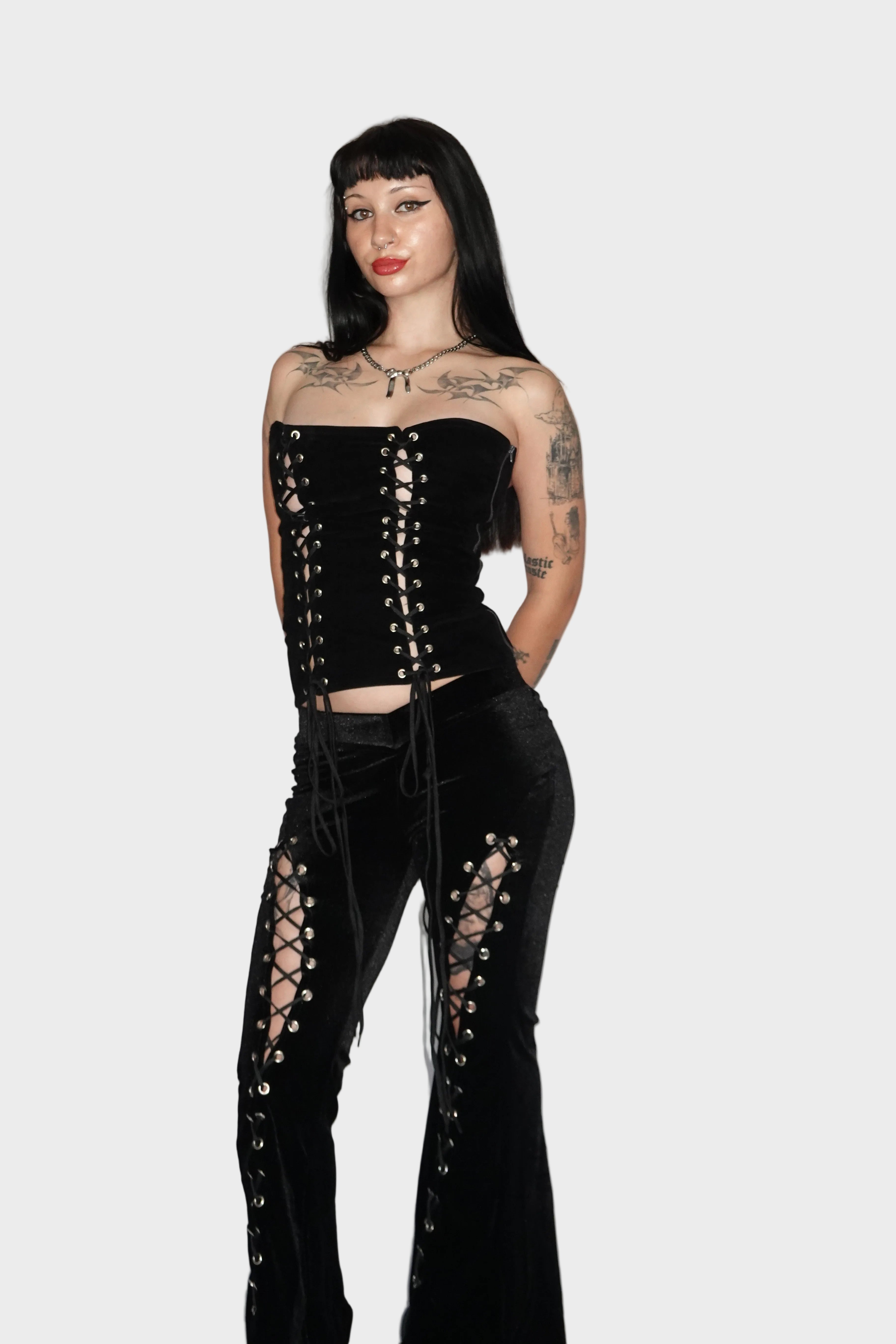 Alt baddie model wearing black velvet alternative flared pants with lace-up cutout leg detail and fitted low-rise V waistband - Ravencross Pants - FM2U Clothing Australia | Gothic Alternative Whimsical Ethical Fashion