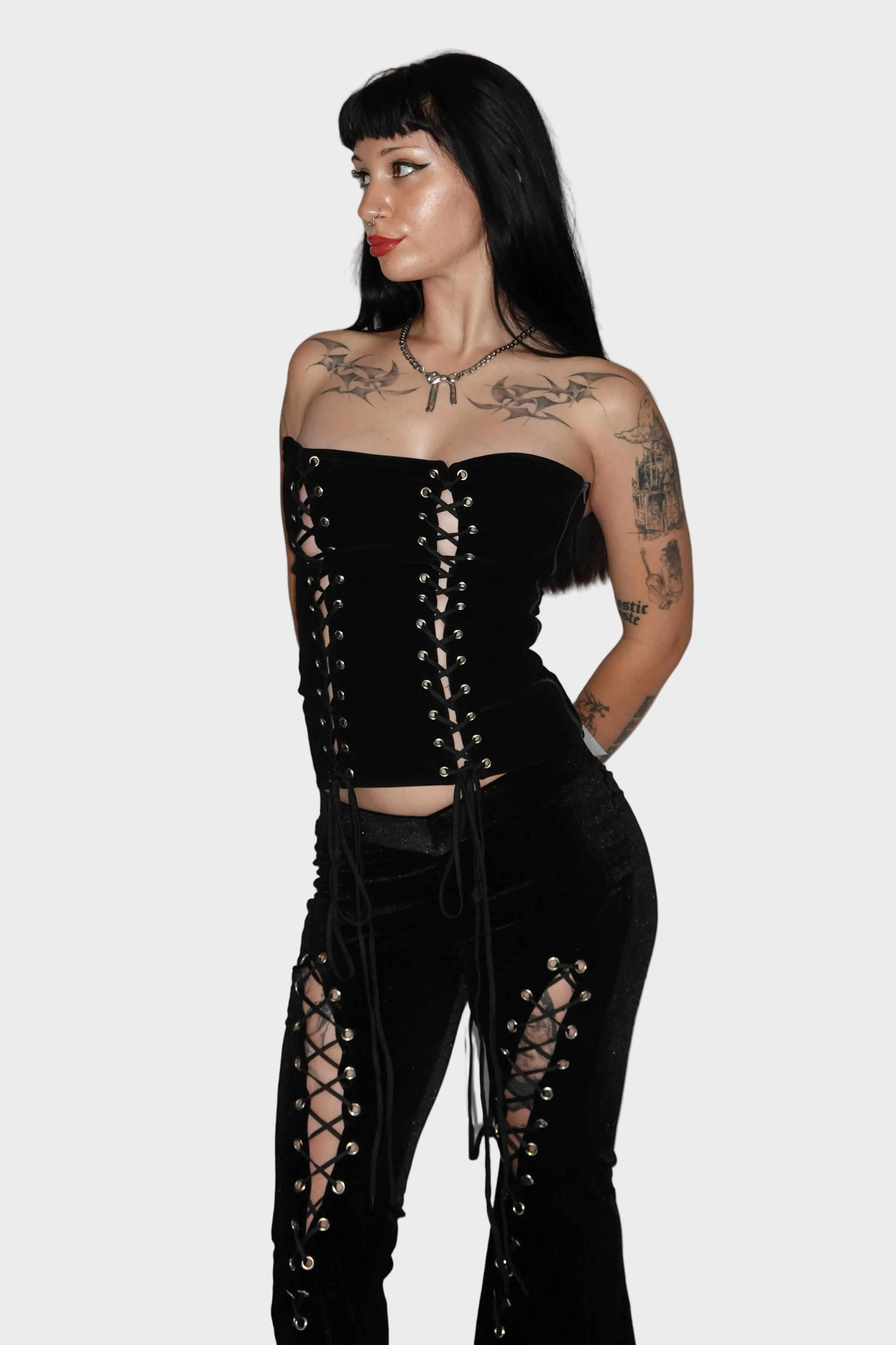 Alt baddie model wearing black velvet alternative flared pants with lace-up cutout leg detail and fitted low-rise V waistband - Ravencross Pants - FM2U Clothing Australia | Gothic Alternative Whimsical Ethical Fashion